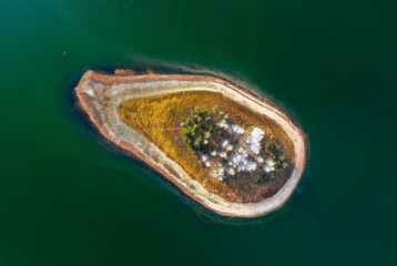 Aerial view of a small island in green water 