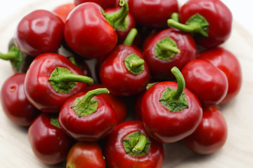 Close-up of red hot chili peppers on plate. Fresh spices ingredients on white background. Red hot chili peppers and fiery emotions. Healthy eating concept 