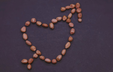 Valentine's day concept: Beautiful heart of the peanuts on the black background. Symbol of lovers.