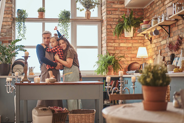 Small happy family is starting their day together at the kitchen.