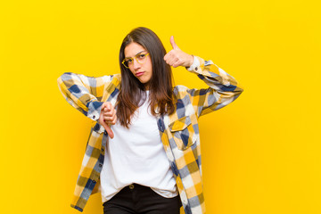 young  pretty woman feeling confused, clueless and unsure, weighting the good and bad in different...