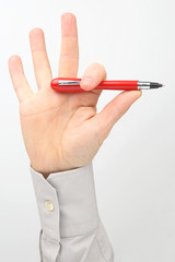 Male hand holds a red pen on a white background