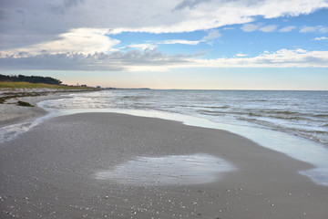 Fototapeta na wymiar Romantic sandy beach with gentle waves around sunset, island Hiddensee on the Baltic coast of Germany