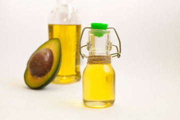 Avocado and avocado oil in bottle on white background. Top view. Copy space.