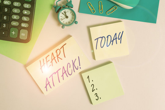 Text sign showing Heart Attack. Business photo showcasing sudden occurrence of coronary thrombosis resulting in death Wire mouse portable calculator notepads paper sheets clips color background