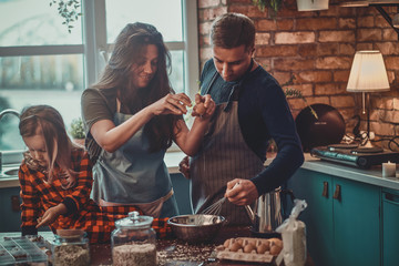 Friendly positive family spending morning at the kitchen, they are cooking breakfast.