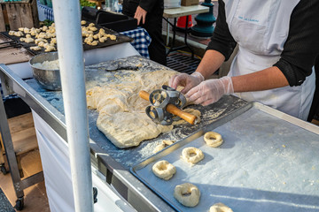 Amish women making fresh doughnuts by hand at outdoor market - Powered by Adobe