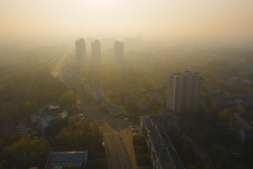 Fototapeta na wymiar Gray toxic smog over the streets of Kiev. Ecological catastrophe of atmospheric air. Air pollution in Kiev in the fall. Atmospheric phenomenon Inversion: fog with smog.