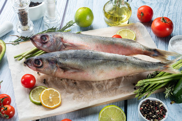 photo seafood and fish on parchment with vegetables on the Board