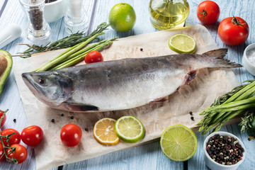 photo seafood and fish on parchment with vegetables on the Board