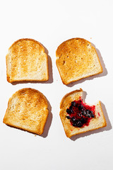 Toasted bread with tasty jam isolated on a white background.Healthy fashion food background with hard shadows.Breakfast brunch concept.Top view,flat lay.Vertical orientation