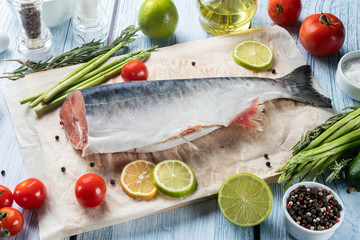 photo seafood and fish on parchment with vegetables on the Board