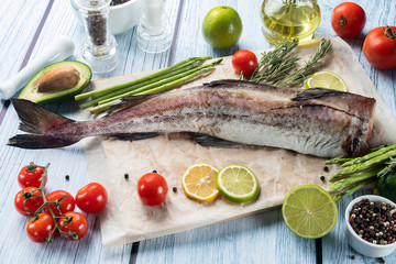 photo seafood and fish on parchment with vegetables on the Board