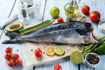 photo seafood and fish on parchment with vegetables on the Board