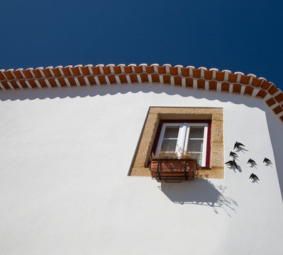 Typical portuguese rustic house with decorative swallows