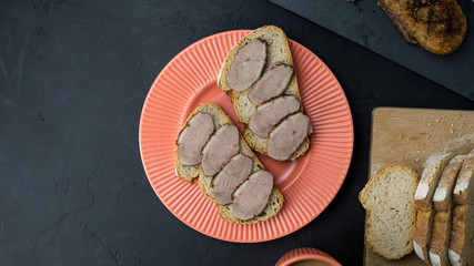 Kanapki z pieczoną gęsią. Pyszne śniadanie, świeży chleb. Widok z góry, ciemne tło, miejsce na tekst. © PhotoHunter