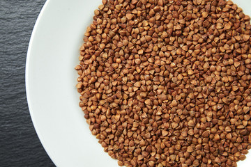 buckwheat in a white plate on a dark background