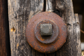 Rusty metal bolt holding a barn together