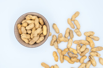 peanuts in shells in a bowl isolated on white background