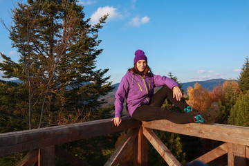 Girl in the mountains in a purple jacket. Autumn Carpathians in Ukraine. Travel.