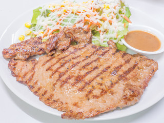 Pork steak and vegetable salad with sauce on the plate