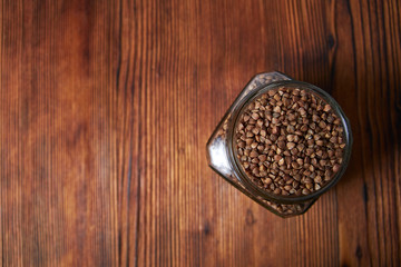 buckwheat in a jar closeup on a brown wood background