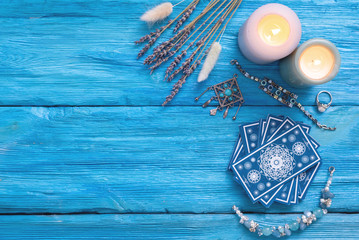 Blue tarot cards deck on blue wooden table flat lay background.