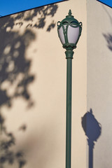 Street lamp and its shadow on a white wall background