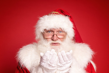 Real Santa Claus portrait. Red studio background.