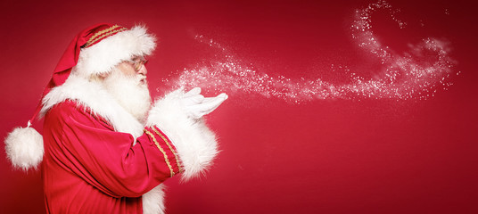 Real Santa Claus on red studio background.