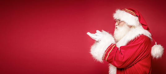 Real Santa Claus on red studio background.