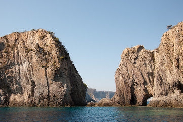 Fototapeta na wymiar Passage berween the rocks in the sea. Rocky cliff (Faraglioni della Madonna) of the mediterranean sea of the island of Ponza in Italy.