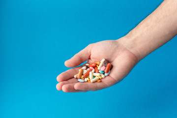 A handful of colored pills on the palm. Medical concept. Shopping at the pharmacy.