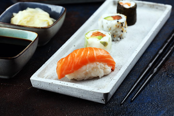 close up of sashimi sushi set with chopsticks and soy - sushi roll with salmon and sushi roll with smoked eel