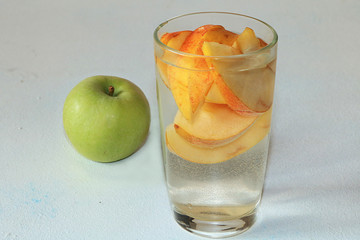 Fototapeta na wymiar Apple cider, juice or fruit drink in a glass on a sunny table. The concept of diet and weight loss. Apples help cleanse the body and reduce weight.