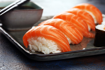 close up of sashimi sushi set with chopsticks and soy - sushi roll with salmon and sushi roll with smoked eel
