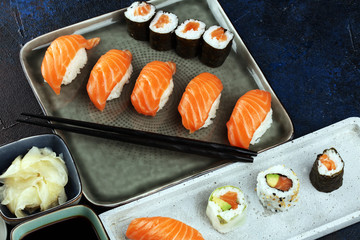 close up of sashimi sushi set with chopsticks and soy - sushi roll with salmon and sushi roll with smoked eel