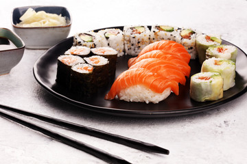 close up of sashimi sushi set with chopsticks and soy - sushi roll with salmon and sushi roll with smoked eel