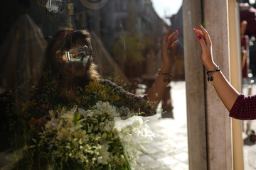 Shop window and model's hand in sunlight. Girl walking on the street and watching luxuty stores windows. Fashionable clothing, beautiful people concept