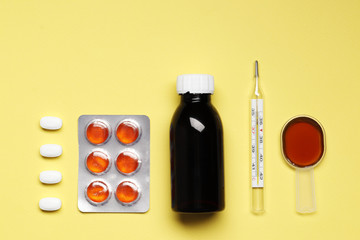  composition from Bottles of cough syrup and Blisters with color cough drops yellow  background