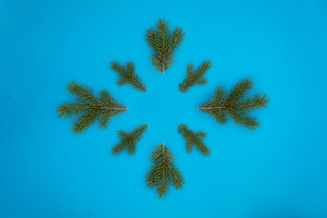 Creative Composition Useful for Christmas and New Year Greeting Card Created Using Eight Green Pine Tree Branches Forming Snowflake Shape