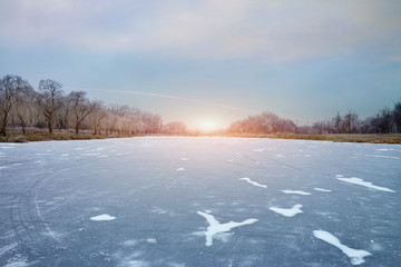 the sun over a frozen lake on a winter evening.