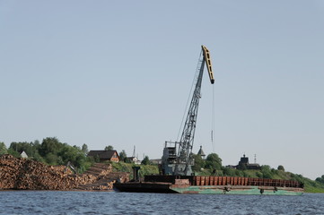loading barge round wood with a crane