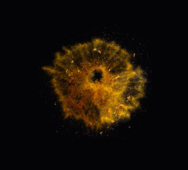 Orange spices powder explosion, flying pepper on black background. Freeze motion photo