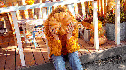 Young adult mother and daughter looking at carved pumpkin with smoke