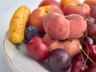 Isolate.Porcelain plate on a white background.On a plate lie juicy ripe fruit