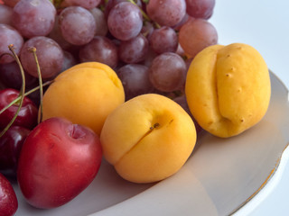 Isolate.Porcelain plate on a white background.On a plate lie juicy ripe fruit