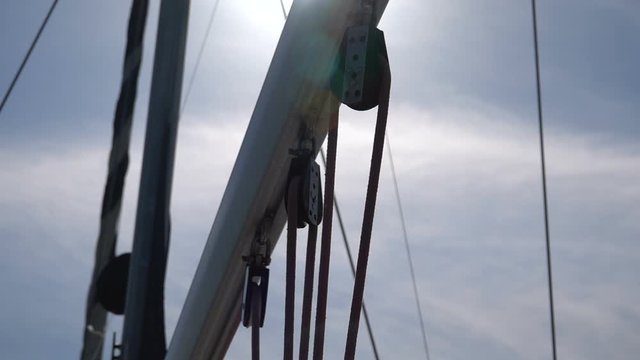 Mast with sheets and rollers on a yacht. Slow motion
