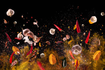 Hot red pepper, garlic, different spices powder meat stakes flying on a black background Motion freeze photo composition - obrazy, fototapety, plakaty