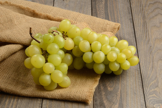 Uvas verdes en la mesa de madera, racimo de uvas